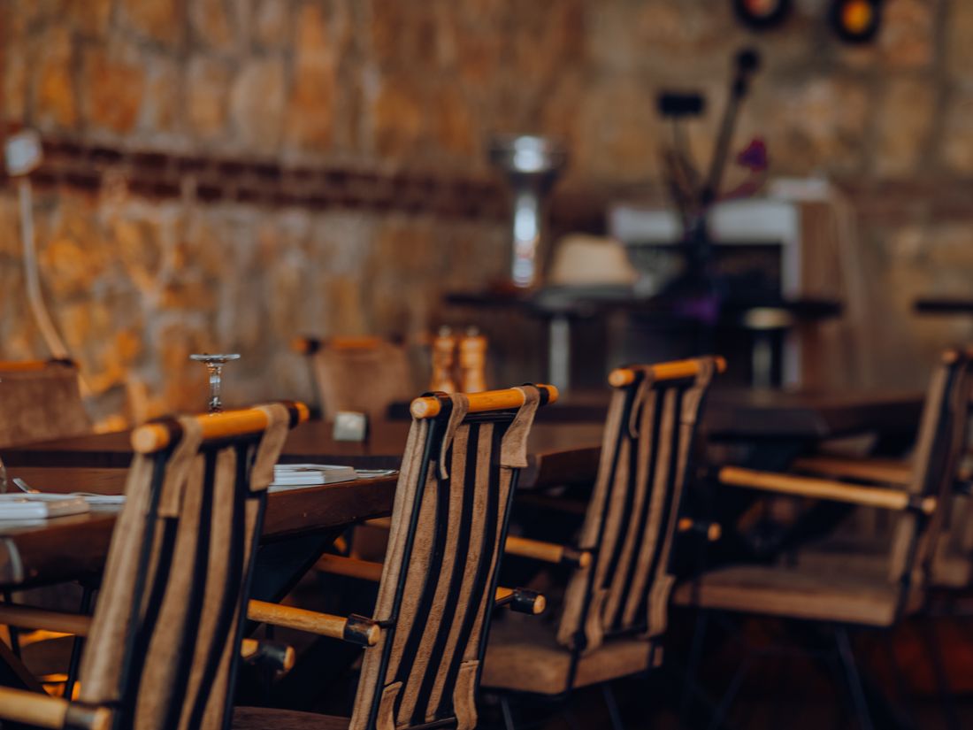 Wooden chairs against a stone wall